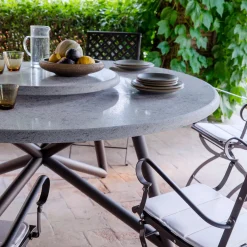 Tavolo da pranzo outdoor rotondo Hermu 150 in pietra peperino grigia e acciaio marrone*Veltha Outdoor Stone Design Online